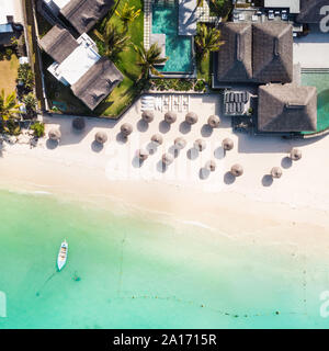 Luftaufnahme von erstaunlichen tropischen weißen Sandstrand mit Palmen und Sonnenschirme türkisblaues Meer, Mauritius. Stockfoto