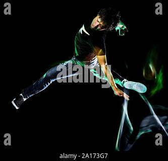 Ein chinesischer Junge Mann hip hop Break Dancer tanzen auf schwarzen Hintergrund mit Geschwindigkeit Licht Malerei Wirkung Bewegungsunschärfe isoliert Stockfoto