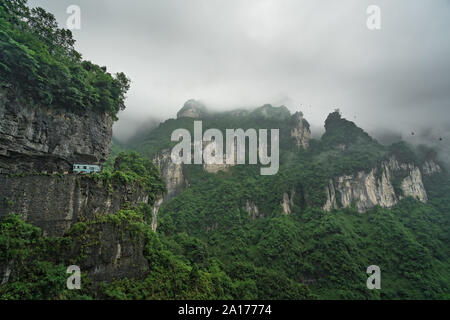 Bus mit Touristen auf die kurvenreiche Straße von 99 wendet sich an die Spitze der Tianmen Mountain, Zhangjiajie Nationalpark, Hunan, China Stockfoto