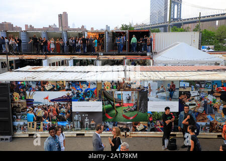 Jährliche Photoville Fotografie Kunst Ausstellung mit Manhattan Bridge im Hintergrund in Brooklyn Bridge Park. Brooklyn New York USA Stockfoto