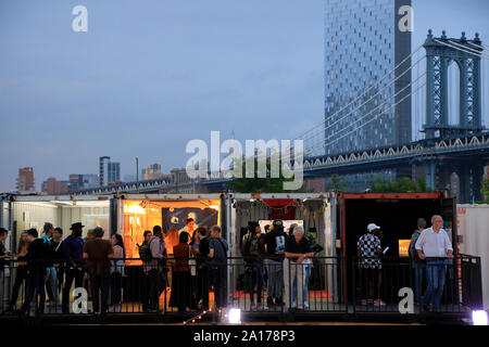 Jährliche Photoville Fotografie Kunst Ausstellung mit Manhattan Bridge im Hintergrund in Brooklyn Bridge Park. Brooklyn New York USA Stockfoto