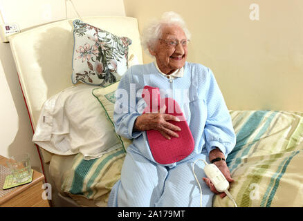 Ältere Dame zu Bett gehen mit einer Heizdecke und Wärmflasche Großbritannien Großbritannien Stockfoto