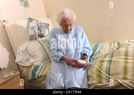 Ältere Dame zu Bett gehen mit einer Heizdecke Großbritannien Großbritannien Stockfoto