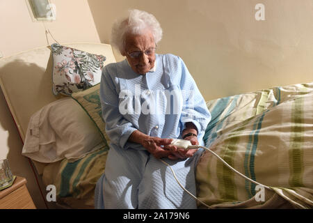 Ältere Dame zu Bett gehen mit einer Heizdecke Großbritannien Großbritannien Stockfoto