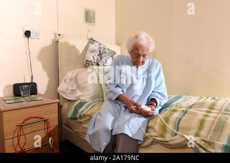 Ältere Dame zu Bett gehen mit einer Heizdecke Großbritannien Großbritannien Stockfoto