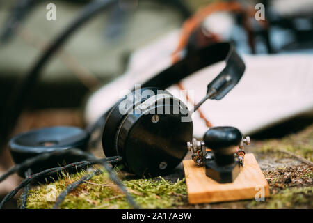 Russisch-sowjetischen Tragbares Radio Transceiver von udssr Red Army Signal Corps im Zweiten Weltkrieg verwendet. Kopfhörer und Fernschreiber Key sind auf einem Baumstumpf. Stockfoto