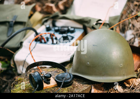 Russisch-sowjetischen Tragbares Radio Transceiver von udssr Red Army Signal Corps im Zweiten Weltkrieg verwendet. Kopfhörer, Fernschreiber, und Helm sind auf einem Wald Stu Stockfoto