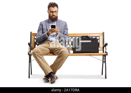 Bärtiger Mann der Texteingabe auf einem Mobiltelefon und auf einer Bank sitzen auf weißem Hintergrund Stockfoto