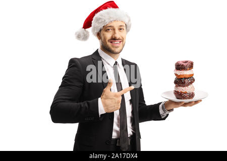 Geschäftsmann mit einem Weihnachtsmann hat eine Platte mit Schokolade Donuts und zeigt auf weißem Hintergrund Stockfoto