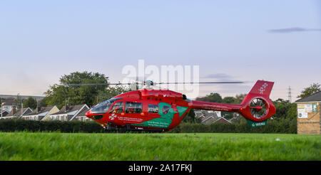 PONTYPRIDD, WALES - September 2019: Weitwinkelaufnahme eines Rettungshubschrauber des Wales Air Ambulance Service am Boden in der Nähe von Häusern Stockfoto