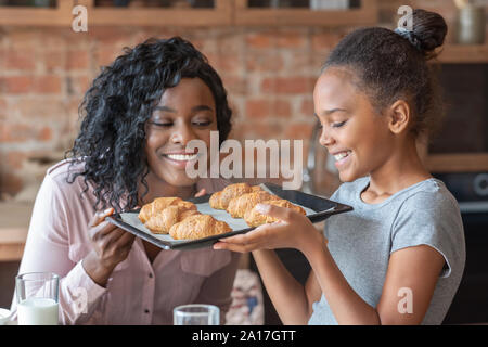 In der Nähe von Mutter und Tochter an gebackenen Croissants suchen Stockfoto