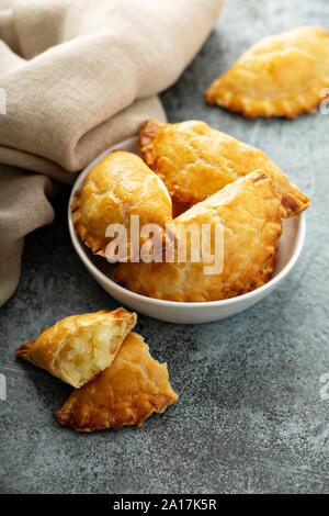 Hand Pasteten, Pasteten, Samosas oder Piroggen mit Kartoffeln füllen Golden gebacken Stockfoto