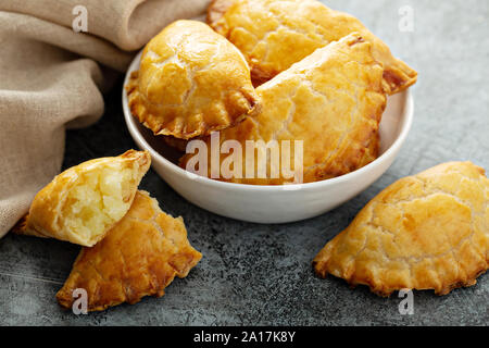 Hand Pasteten, Pasteten, Samosas oder Piroggen mit Kartoffeln füllen Golden gebacken Stockfoto