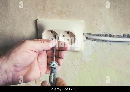 Reparatur von Steckdosen in der Wand des Hauses.Alte kaputte Lichtschalter mit Stromanschluss in alten kaputten Fabrik. Selektiver Fokus Stockfoto