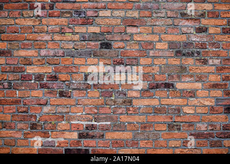 Old Red Brick Wall mit viel Struktur und Farbe. Stockfoto