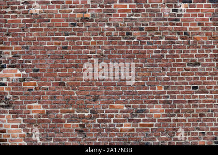 Old Red Brick Wall mit viel Struktur und Farbe. Stockfoto