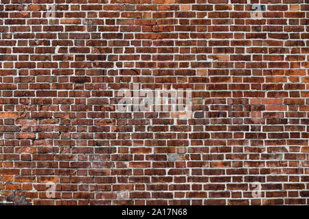 Old Red Brick Wall mit viel Struktur und Farbe. Stockfoto