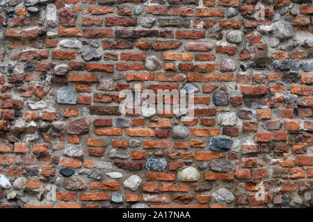 Old Red Brick Wall mit viel Struktur und Farbe. Stockfoto