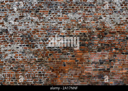 Old Red Brick Wall mit viel Struktur und Farbe. Stockfoto