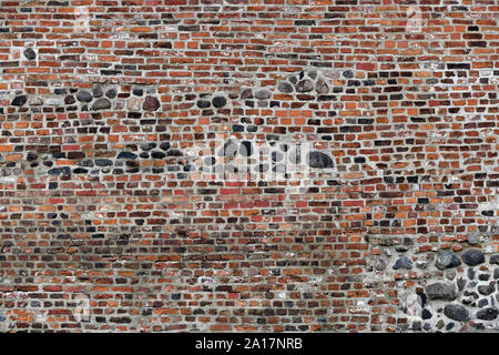 Old Red Brick Wall mit viel Struktur und Farbe. Stockfoto