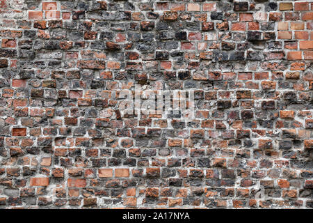 Old Red Brick Wall mit viel Struktur und Farbe. Stockfoto