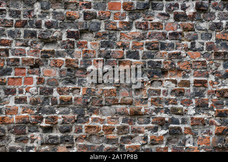 Old Red Brick Wall mit viel Struktur und Farbe. Stockfoto