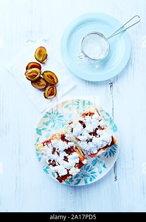 Zwei Stücke selbstgemachten Pflaumenkuchen auf einem Teller. Natürliche backen. Rustikale Holz Hintergrund. Ansicht von oben. Flatlay Stockfoto