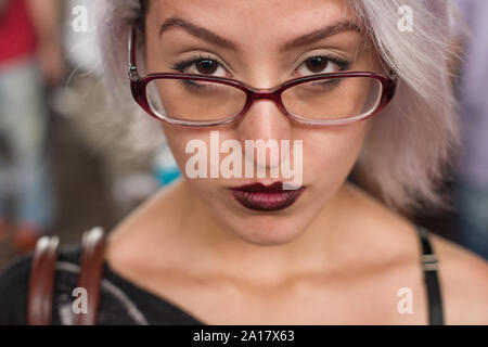 Junge Frau mit weißen Haaren, dunklen roten Lippen und Gläser Stockfoto