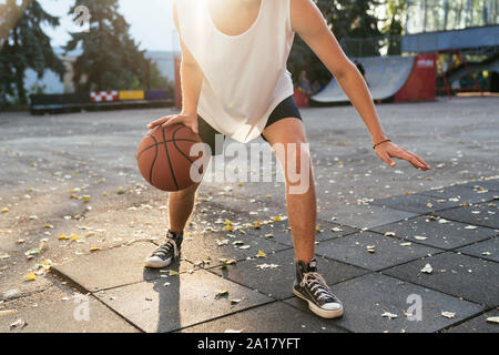 Männer mit kurvigen Haar Basketball spielen im Freien, in der Nähe Stockfoto