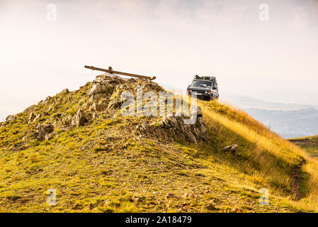 Zlatibor, Serbien - Juli 30., 2019. Vintage off road Auto auf der Oberseite des Golden Hill mit dem Lügen Kreuz auf der Oberseite Stockfoto