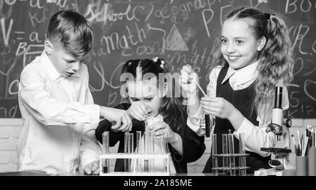 Die Fokussierung auf die Arbeit. Kleine Kinder im Labor. Studenten, Biologie Experimente mit Mikroskop. Labor Mikroskop. Tag der Kinder. Chemie Mikroskop. Kleine Kinder lernen die Chemie in der Schule lab. Stockfoto