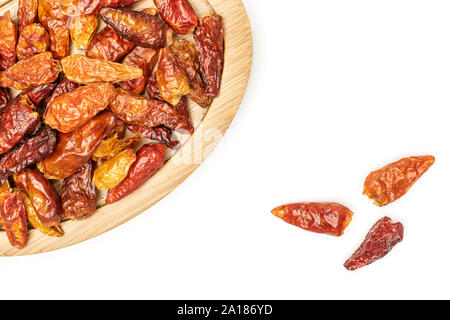 Menge ganze trockene rote Chili peperoncino auf Bambus Platte flatlay auf weißem Hintergrund Stockfoto