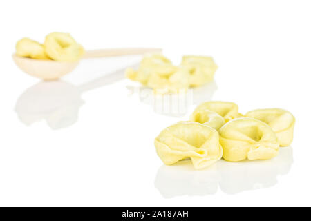 Menge ganze frische Gelb Spinat gefüllte Tortelloni in einem Kochlöffel auf weißem Hintergrund Stockfoto