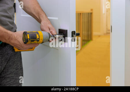 Heimwerker Installation der Tür im Zimmer mit Schraubendreher, Close-up der neuen ein Haus auf der offenen Tür Stockfoto