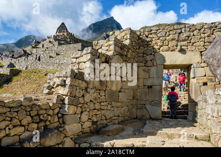 Machu Picchu Sonnenaufgang, Heiliges Tal der Inkas, Peru. Touristen am Haupttor, Portal der verlorenen Stadt, Machu Pichu antike Ruinen, frühen Morgen, Peru Stockfoto