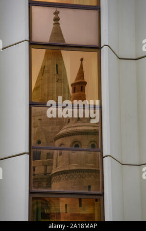 Budapest, Ungarn - 19. Mai 2010: Reflexion der Turmspitze der Fischerbastei im Fenster Glas, Budapest, Ungarn Stockfoto