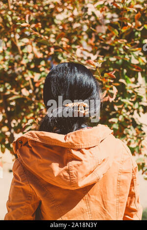 Herbst Frau. Herbst Jahreszeit Konzept. Frau beobachten Herbst Blätter fallen. Ansicht von hinten. Herbst oder fallen Frau. Sonnige herbst Wetter im Freien Stockfoto