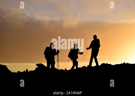 Silhouetten von drei Menschen wandern auf den Azoren Insel in Portugal Stockfoto