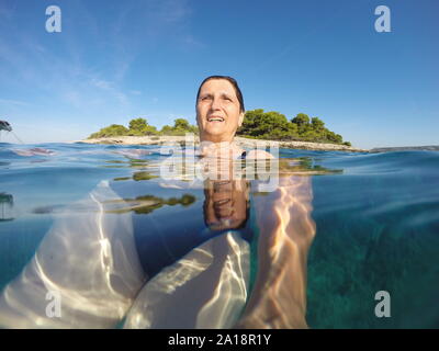 Reife Frau Schwimmen im klaren, blauen Adria Stockfoto