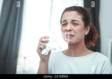 Curly Frau mit Serviette Niesen, weil der Allergie Stockfoto