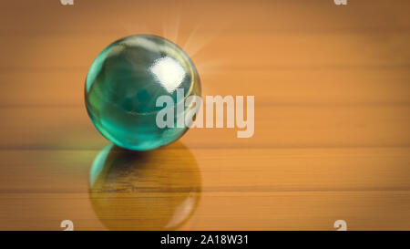 Dunkelgrün glas kugel auf die dunklen Glasfläche. Freier Platz für Ihren Text oder Bild. Zusammenfassung Hohe Auflösung Makrofotografie mit 16:9 Pro Stockfoto