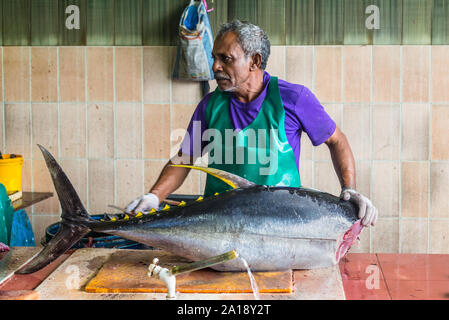 Male, Malediven - November 16, 2017: Man bereitet frischen Fisch (Thunfisch) zum Verkauf auf dem Fischmarkt in der Stadt und der Insel Male, die Hauptstadt der Malediven Stockfoto