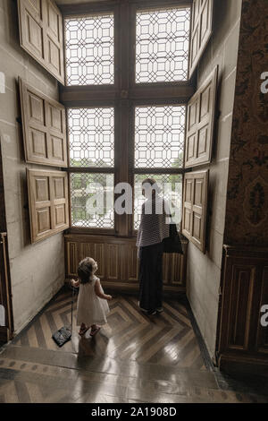 Europa Frankreich Chenonceaux: 2019-07 ein Kind und ein junges Mädchen am Fenster im Schloss Chenonceau, eine Struktur, die den Fluss Cher. Stockfoto