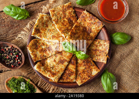 Grissini aus Blumenkohl, Käse und Kräutern, mit frischem Basilikum und rote Sauce serviert. Stockfoto