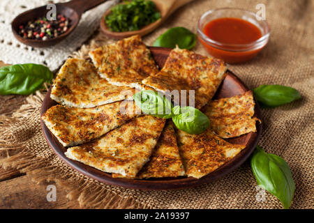 Grissini aus Blumenkohl, Käse und Kräutern, mit frischem Basilikum und rote Sauce serviert. Stockfoto