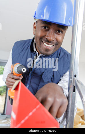 Erbauer mit cordless Power Tool erreichen für Schrauben Stockfoto