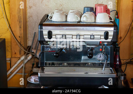 Elektrische Kaffeemaschine mit Tassen auf die Oberseite in eine Bar oder ein Café für köstliche Getränke. Stockfoto