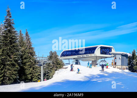 Bansko, Bulgarien - Dezember 20, 2018: Ski Resort view mit Skipiste, Leute unten Skifahren von Kolarski 6-Sitzer ski Sessellift Stockfoto