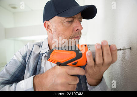 Man bohren die Wand mit Bohrer perforator Stockfoto