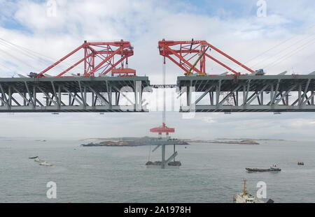 (190925) - FUZHOU, Sept. 25, 2019 (Xinhua) - Luftaufnahme auf Sept. 21, 2019 zeigt einen stahlträger von einem Kran auf der Baustelle des Pingtan Meerenge Straße - Schiene Brücke im Südosten der chinesischen Provinz Fujian. China am Mittwoch abgeschlossen Die Struktur der längsten der Welt - Sea Road - Eisenbahnbrücke in Fujian. Die letzte Stahlträger, mit einem Gewicht von 473 Tonnen, war auf der Pingtan Meerenge Straße verschraubt - Rail Bridge, ein mega Projekt in China, am Mittwoch Morgen. Mit einer Spannweite von 16.34 m, die Brücke verbindet Pingtan Insel und vier nahe gelegenen Inseln zu den wichtigsten Stockfoto